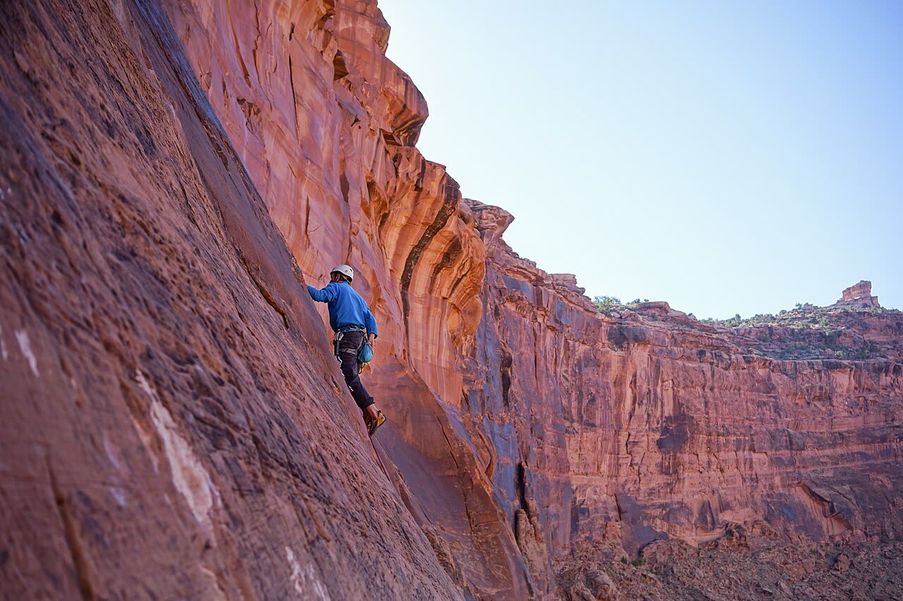 Climber on a red cliff wall