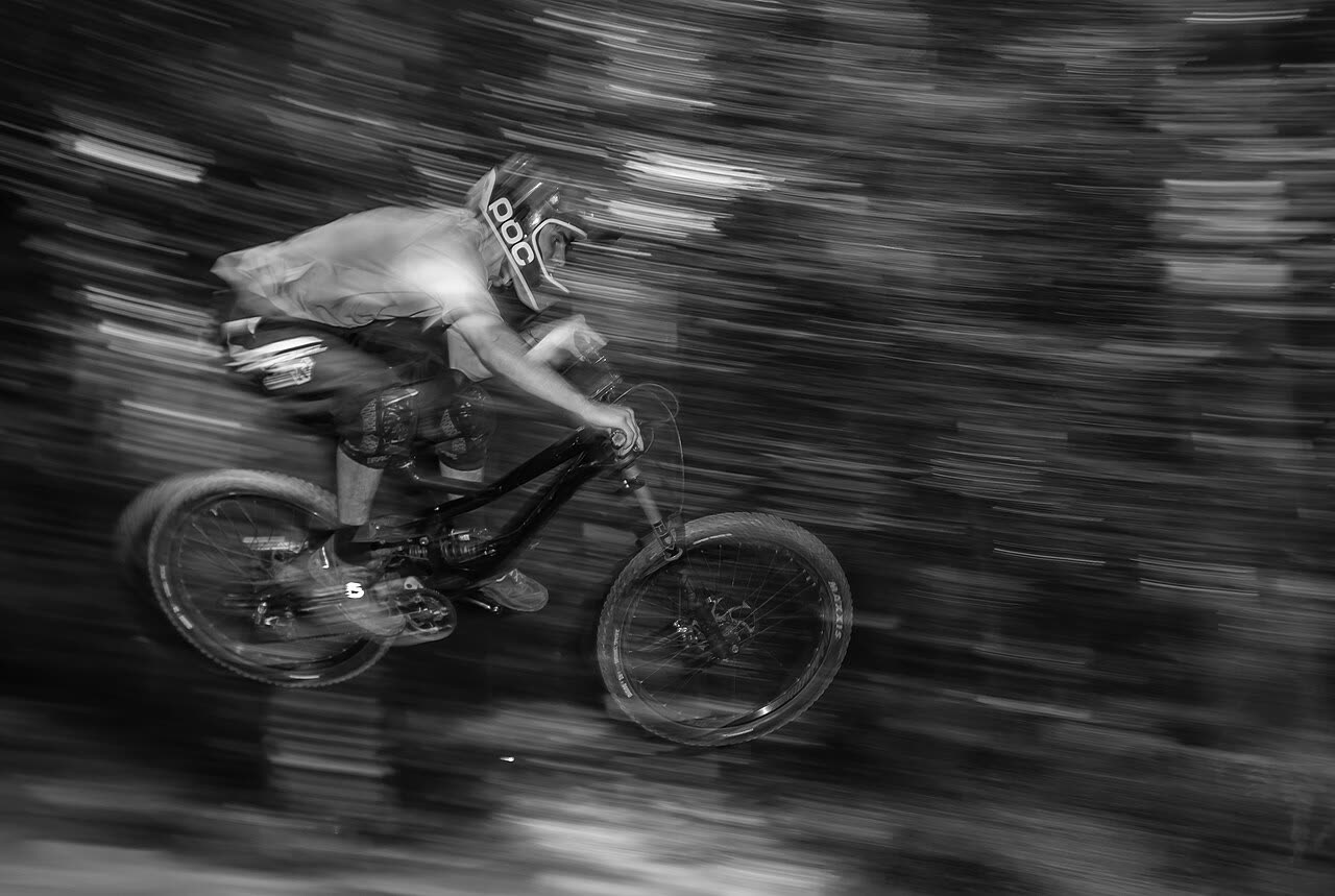 Downhill mountain biker blurred with speed